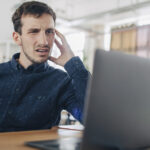Egy irodai dolgozó adatvesztés miatt aggódik a laptopja előtt